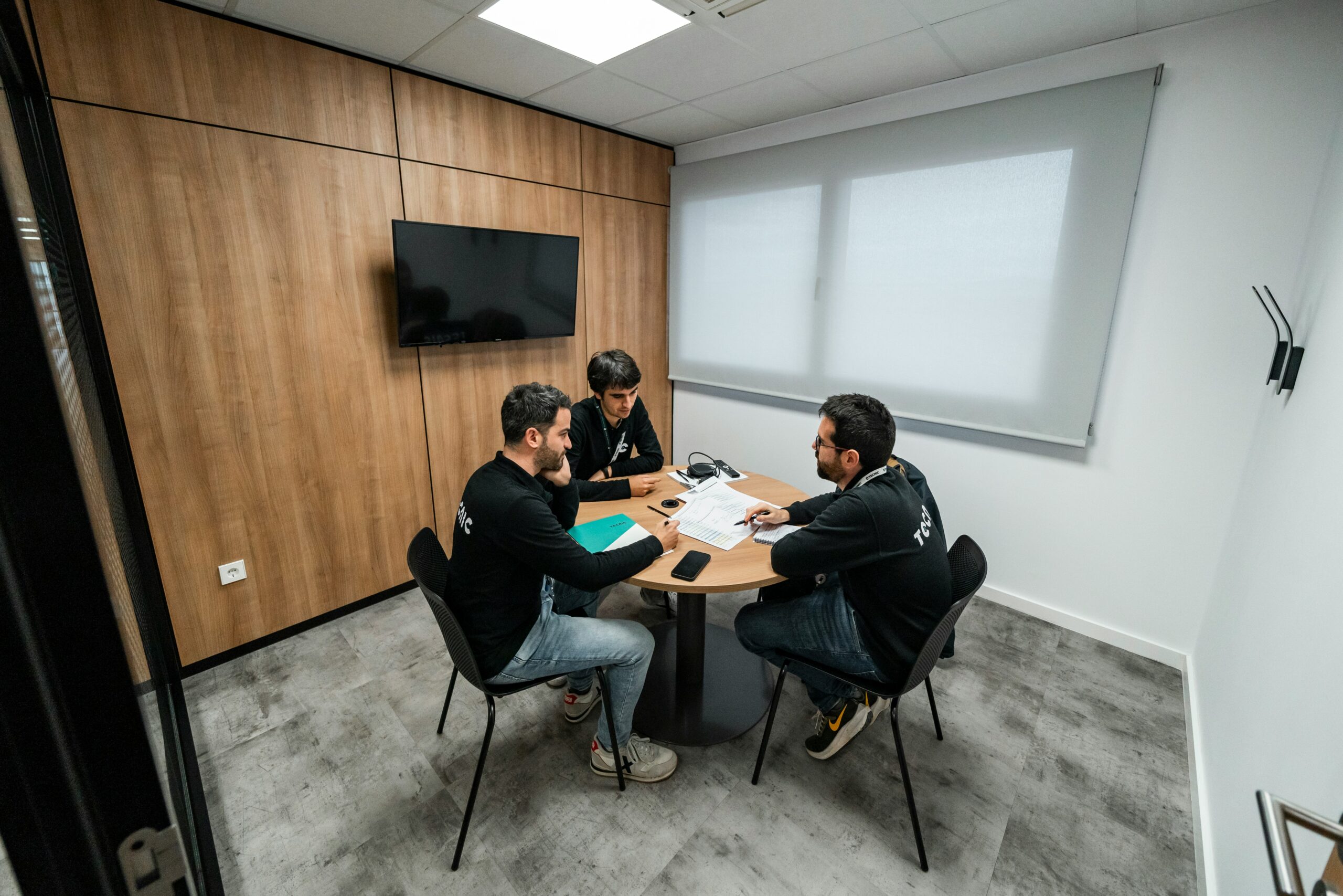 Three direct sales professionals sitting around a small round table in a meeting room